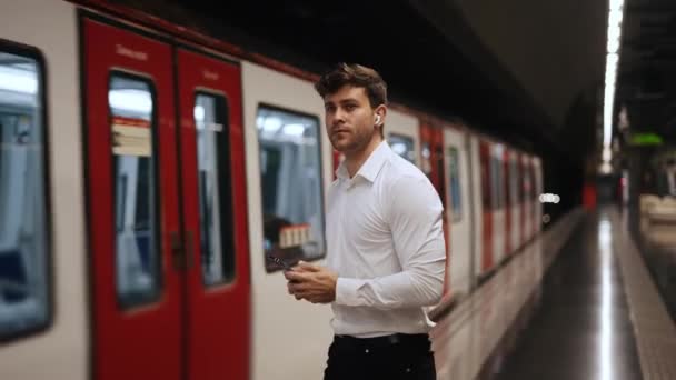 Üzletember, a smartphone a vonattal vár — Stock videók