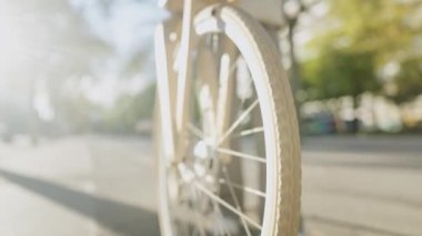 Kaldırımda yürüyen kadın bisikletçi.