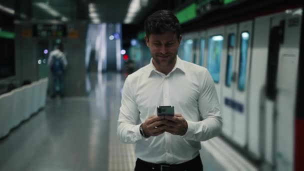 Positive male manager with cellphone walking on platform — Stock Video