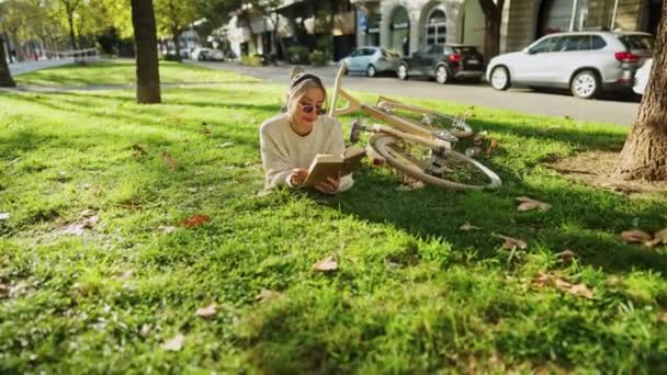 Mujer leyendo libro en el parque en tiempo libre — Vídeos de Stock
