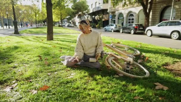 Movimento Lento Mulher Elegante Sentado Grama Perto Bicicleta Madeira Enquanto — Vídeo de Stock