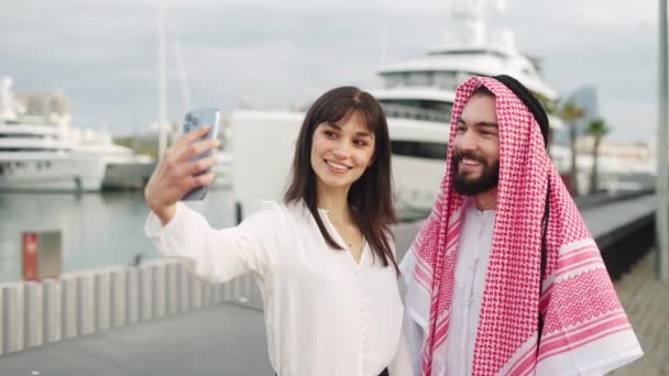 Joven empresaria europea tomando selfie con cliente árabe feliz hombre después de un acuerdo exitoso en el puerto — Vídeos de Stock