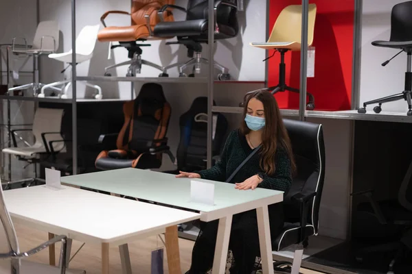 Mujer eligiendo mesa en tienda Imagen de archivo