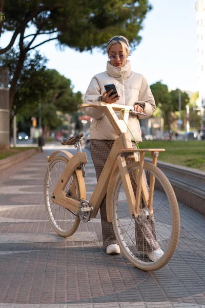 공원에서 핸드폰을 사용하는 유행하는 자전거 운전자 — 스톡 사진