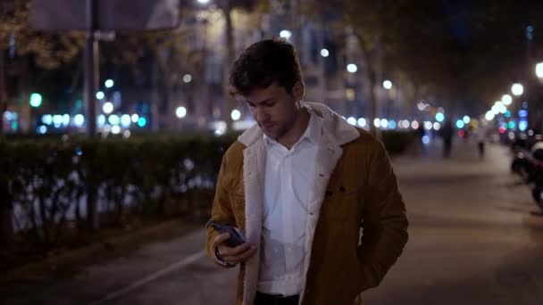 어두운 거리에서 휴대 전화를 검색하는 남자 — 비디오