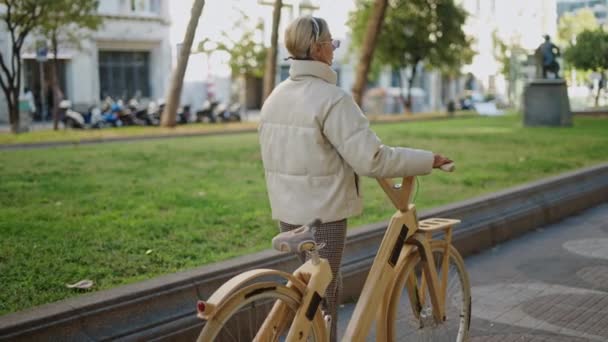 Mujer con bicicleta caminando en el parque — Vídeo de stock