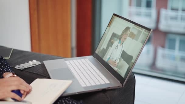 Pantalla para computadora portátil con médico femenino en bata blanca y estetoscopio que proporciona atención médica a distancia — Vídeo de stock