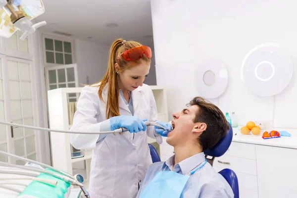 Dentiste utilisant outil perceuse dentaire sur le patient — Photo