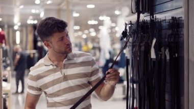 Erkek alıcı mağazadan deri kemer seçiyor