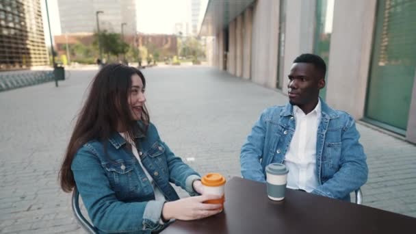 Χαρούμενο πολυεθνικό ζευγάρι πίνοντας καφέ στην πόλη — Αρχείο Βίντεο