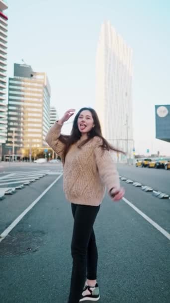 Mujer positiva divirtiéndose y mostrando la lengua en la calle — Vídeos de Stock