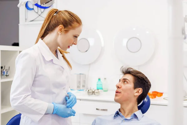 Мужчина и женщина разговаривают в кабинете дантиста — стоковое фото