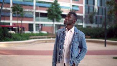 Siyah adam şehirdeki gökdelenlere bakıyor.