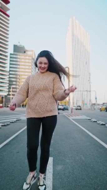 Positieve vrouw loopt langs straat en draait zich om — Stockvideo