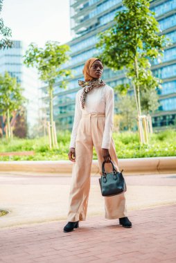 Moda kıyafetli ve tesettürlü kendine güvenen siyah kadın.