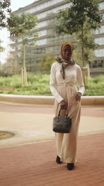 Αυτοπεποίθηση μαύρη γυναίκα σε μοντέρνο ντύσιμο και hijab κρατώντας τσάντα — Αρχείο Βίντεο