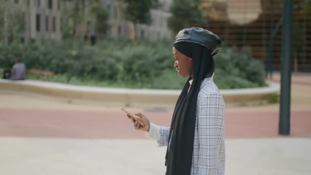 Moslim vrouw met smartphone op straat — Stockvideo
