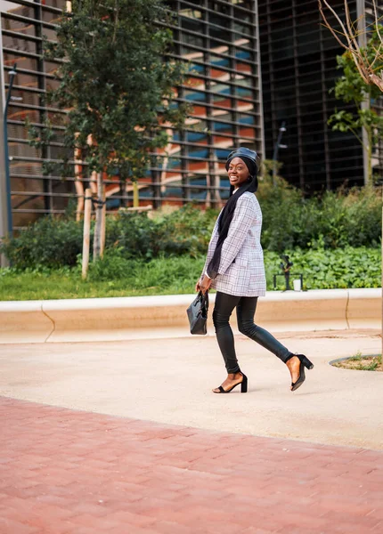 都会の公園で楽しい散歩を楽しむスタイリッシュな黒人女性 — ストック写真