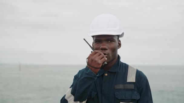 Marinero afroamericano habla con radio walkie-talkie VHF en las manos — Vídeo de stock