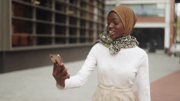 Moslim vrouw het maken van video call op straat — Stockvideo