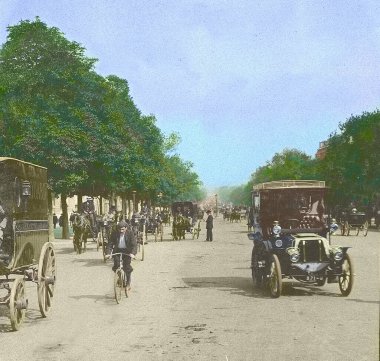 Paris, Fransa, 1900 dolayları. Eski fotoğraf el boyası. Paris 'te bir araba. Champs Elysees caddesindeki ilk otomobiller. Siyah beyaz resimdeki renkli resim görüntüsü. Ağaçlar, arabalar, fayton, atlar ve bisikletler.