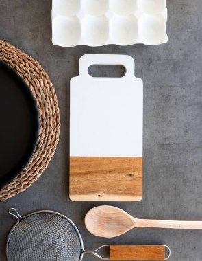 Koyu gri arka planda mutfak gereçleri, tahta, elek, kaşık, pişirme tabağı