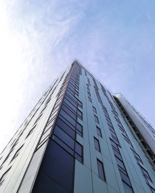 Mavi gökyüzü ve bulutlara karşı bir ofis binasının köşesi