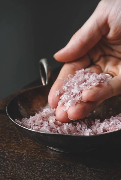 Flakes of pink wine salt in a woman\'s hands