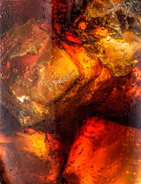 Ice cubes in the cola drink closeup.