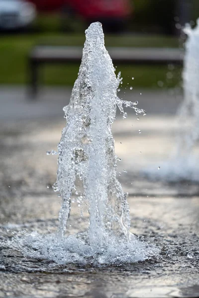Frozen spray, visible drops of water in the air. Fountain from underground — Stock Photo, Image