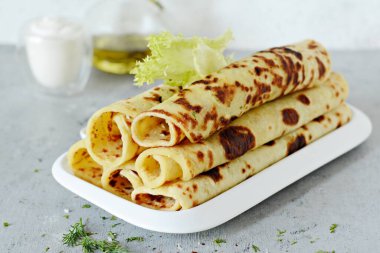 Peynir ve yeşilliklerle donatılmış hafif arka planda Norveç patatesli krep Lefse. Geleneksel İskandinav mutfağı.
