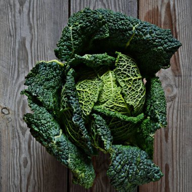 Koyu ahşap arka planda taze savoy lahanası. Sağlıklı beslenme kavramı, vejetaryen ol..