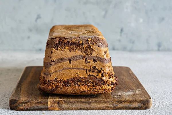 Çikolatalı mermer pasta (bisküvi) Zebra çikolatalı krema ile tahta tahtada gri bir zemin üzerinde. Ev yapımı tatlı..