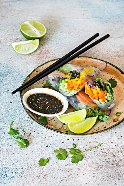 Pirinç kağıdı, çiğ sebze ve açık mavi arka planda acı soslu bitkilerden yapılmış taze Asya aperatifli börekler (Nem). Vietnam Yemekleri