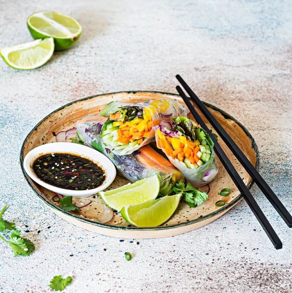 Pirinç kağıdı, çiğ sebze ve açık mavi arka planda acı soslu bitkilerden yapılmış taze Asya aperatifli börekler (Nem). Vietnam Yemekleri