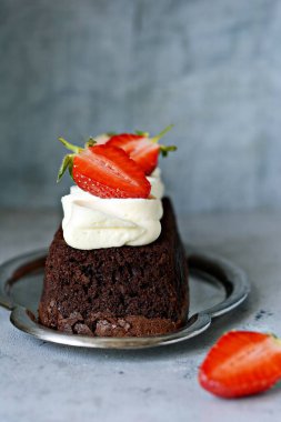 Çikolatalı brownie (kek), vanilya kremalı ve taze çilekli (çilek). Çay tatlısı.