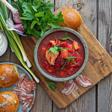 National dish of Ukrainian cuisine borscht with vegetables, turkey meat, herbs, sour cream and traditional bread (bun with garlic and dill, pampushka) with bacon (pork). Cultural heritage.