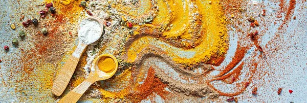 Variety of spices on a blue background. Powdered dried garlic, dried onions, smoked paprika, turmeric, curry, cinnamon and coriander for cooking. Indian and Asian cuisine, Seasonings