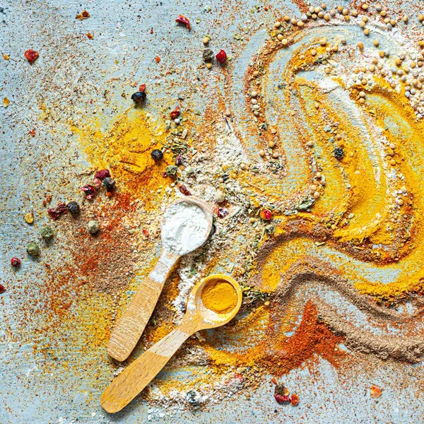 Variety of spices on a blue background. Powdered dried garlic, dried onions, smoked paprika, turmeric, curry, cinnamon and coriander for cooking. Indian and Asian cuisine, Seasonings