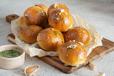 Tahta bir tahtanın üzerinde ilk yemek olarak taze pişmiş çörekler (pampushki) sarımsak ve dereotlu (çorba). Ulusal Ukrayna yemeği, yemek. Seçici odak.