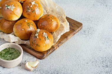 Tahta bir tahtanın üzerinde ilk yemek olarak taze pişmiş çörekler (pampushki) sarımsak ve dereotlu (çorba). Ulusal Ukrayna yemeği, yemek. Seçici odak.