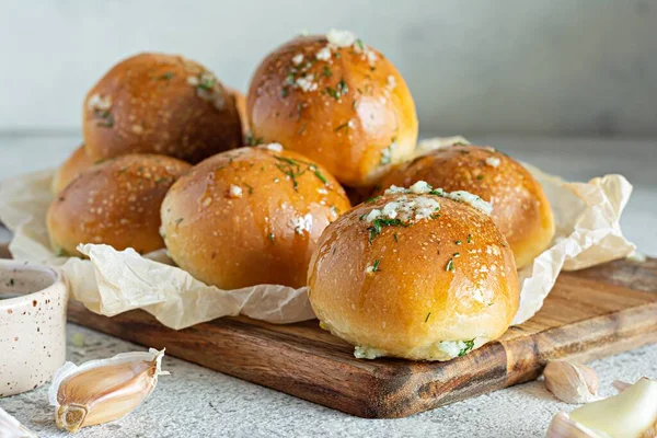 Tahta bir tahtanın üzerinde ilk yemek olarak taze pişmiş çörekler (pampushki) sarımsak ve dereotlu (çorba). Ulusal Ukrayna yemeği, yemek. Seçici odak.