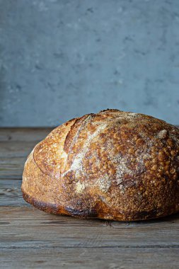 Gri-mavi arka planda tahıl unlu taze ev yapımı ekşi ekmek. Sağlıklı yemek..