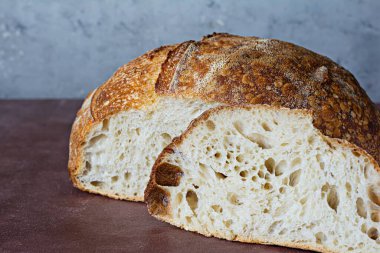 Gri-kahverengi arka planda tahıl unlu taze ev yapımı ekşi ekmek. Sağlıklı yemek..