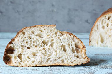 Gri-mavi arka planda tahıl unlu taze ev yapımı ekşi ekmek. Sağlıklı yemek..