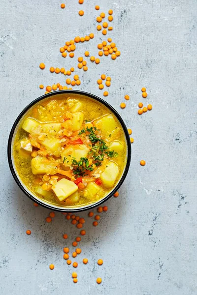 stock image Soup with red lentils and vegetables in a bowl on a blue background.Traditional dish of Turkish or Arabic cuisine, vegan healthy food.