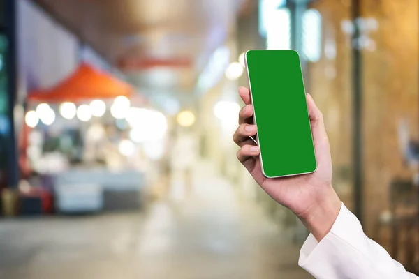 Alışveriş merkezinde cep telefonu tutan iş kadını.