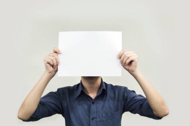 Gri arka planda pankart için elinde boş bir kağıt tutan elleri kapatın.