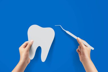 Kapalı diş hekimi, elinde diş hekimi ve hasta dişini muayene ediyor..