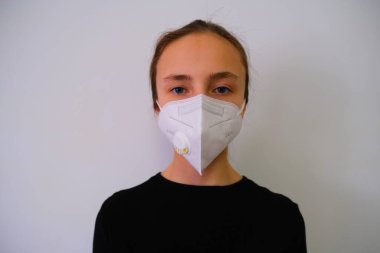Coronavirus. Koronavirüs koruyucu bir maske taktığı için kız karantinaya alındı. Maskeli kız viral bir salgın hastalıktan endişeleniyor. Korunmuş.